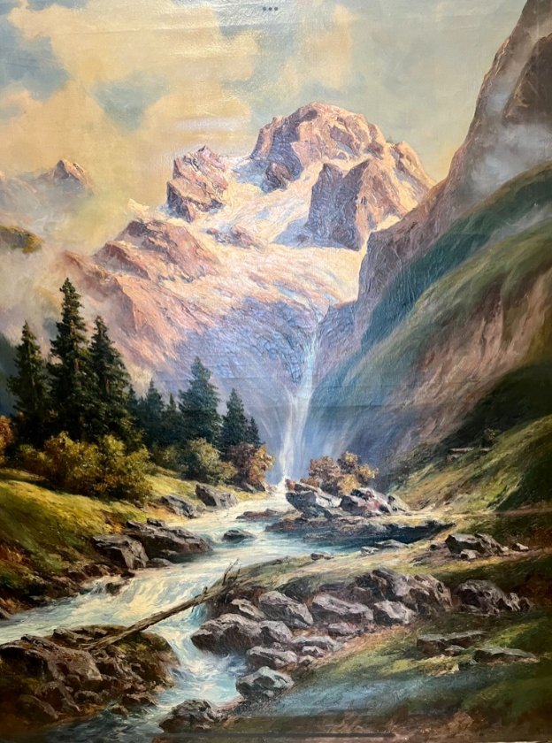 A large alpine landscape with rapids in the foreground